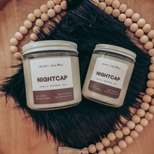 Load image into Gallery viewer, Two 'Nightcap' candles from Desert Liliberles on a wooden surface with feathers and beads.