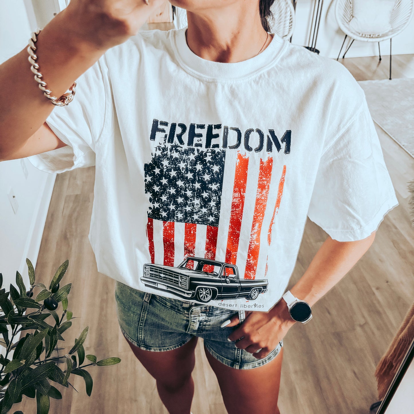 Person wearing a white t-shirt with 'Freedom' and an American flag graphic.