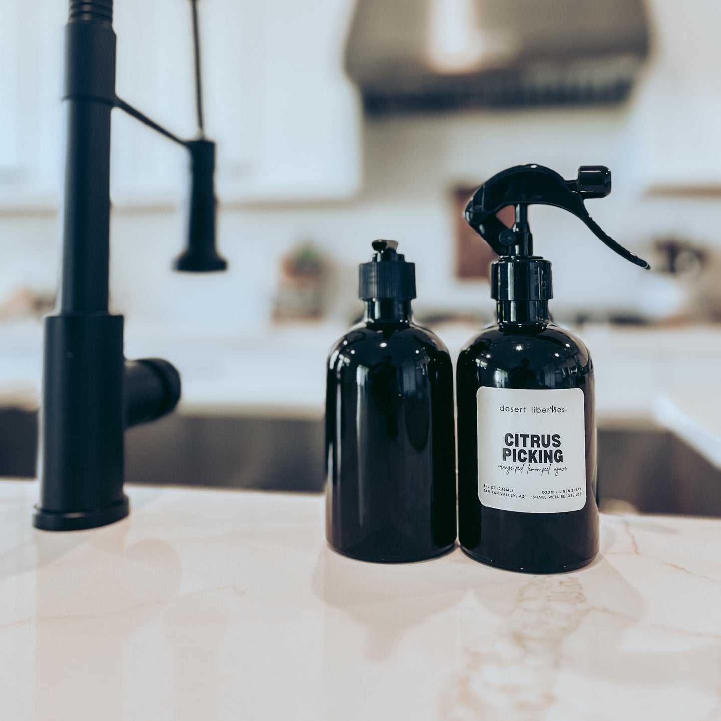 Two black bottles with pump dispensers on a kitchen counter.