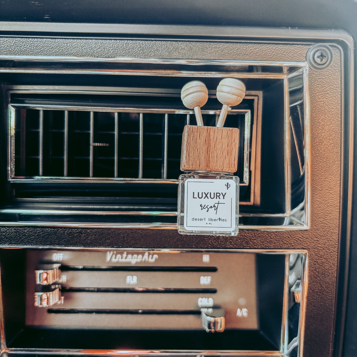 Car air freshener with 'Luxury' branding in a car's air vent.