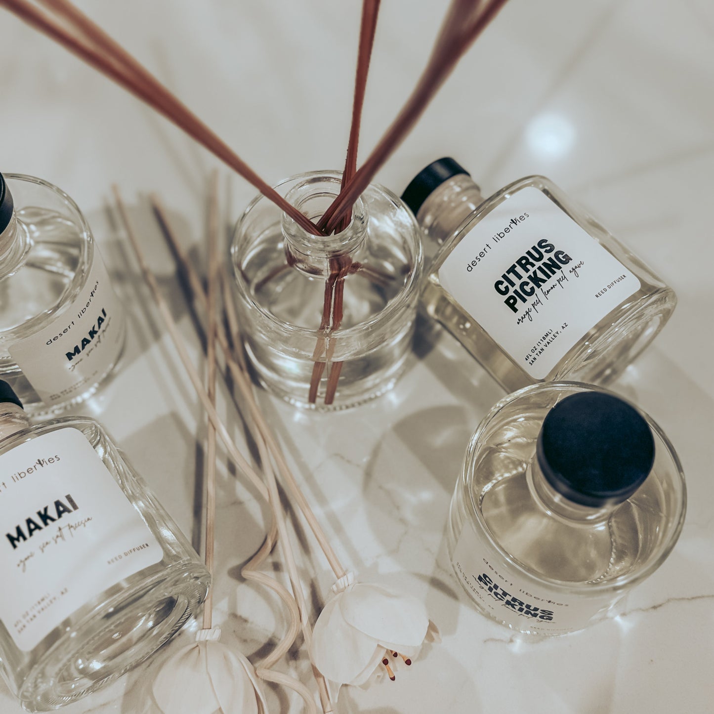 Set of diffuser bottles with reeds on a marble surface
