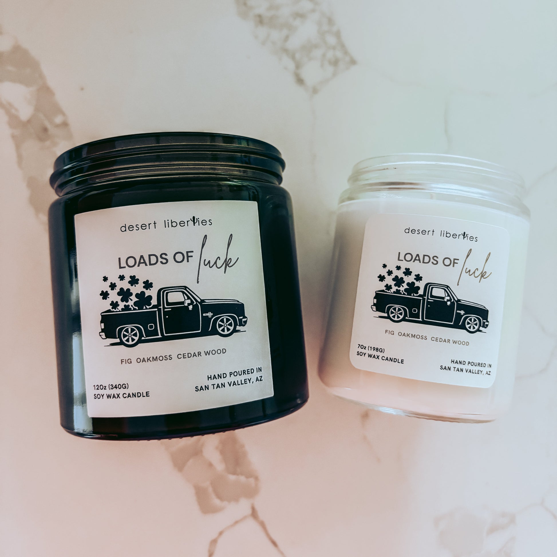 Two candles with labels on a marble surface