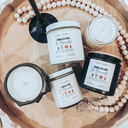 Four candles with labels on a wooden tray with beads