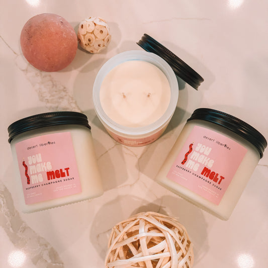 Three candles with pink labels on a light surface