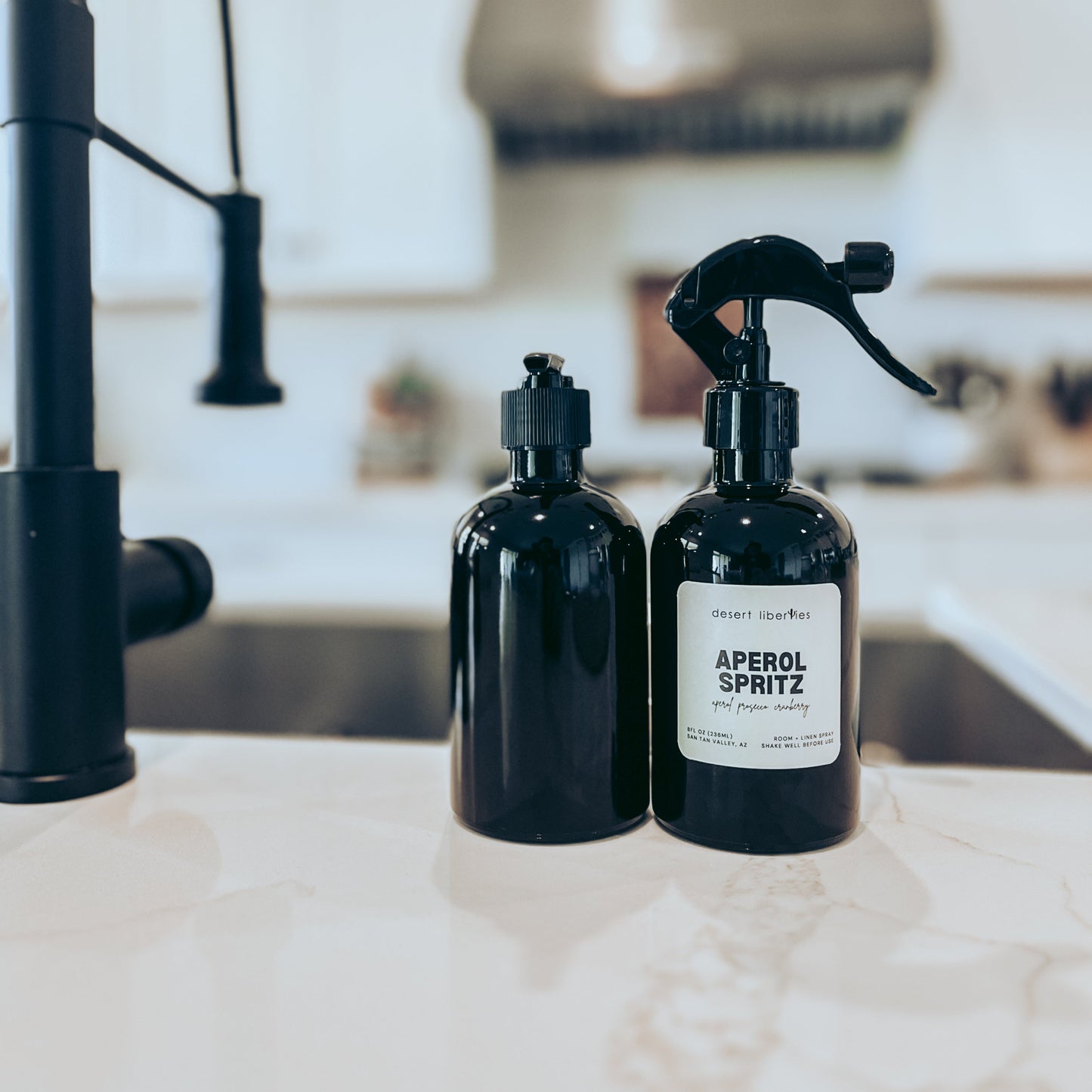 Two black bottles with labels on a kitchen counter