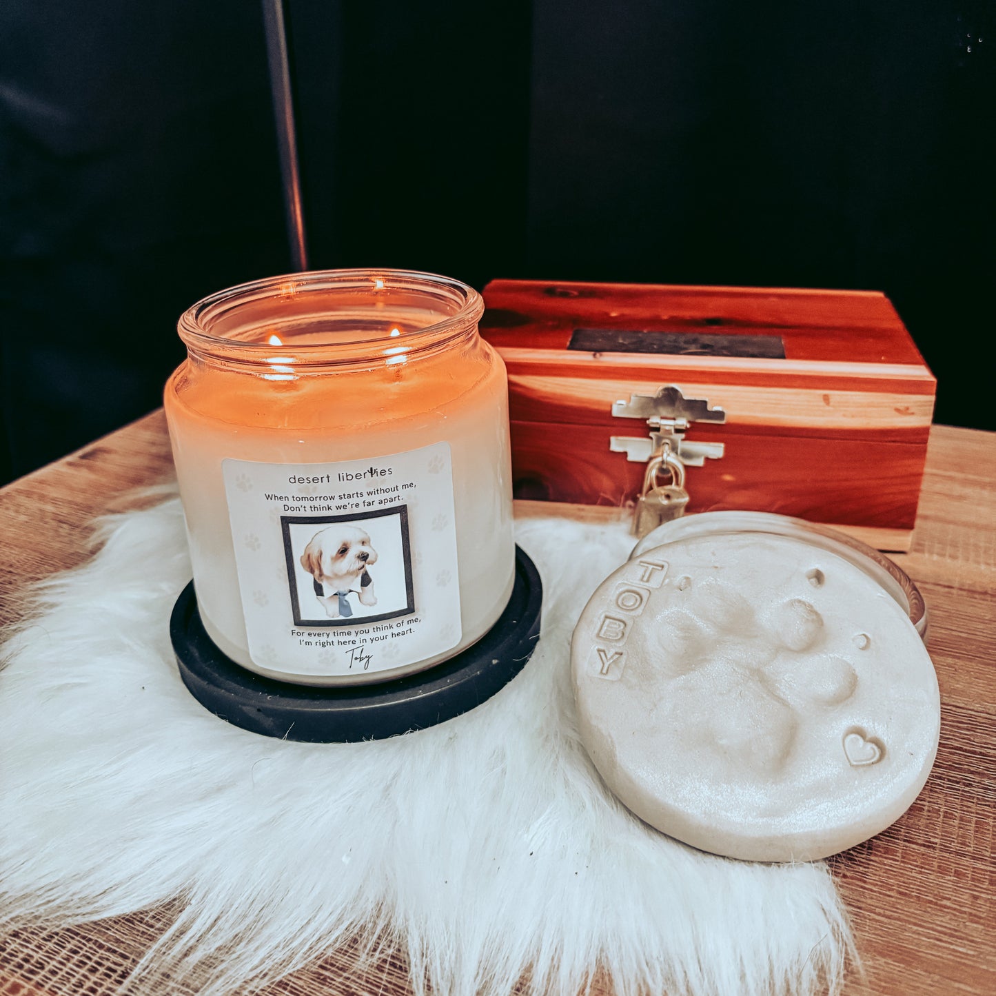 Candle with a wooden box and decorative item on a textured surface
