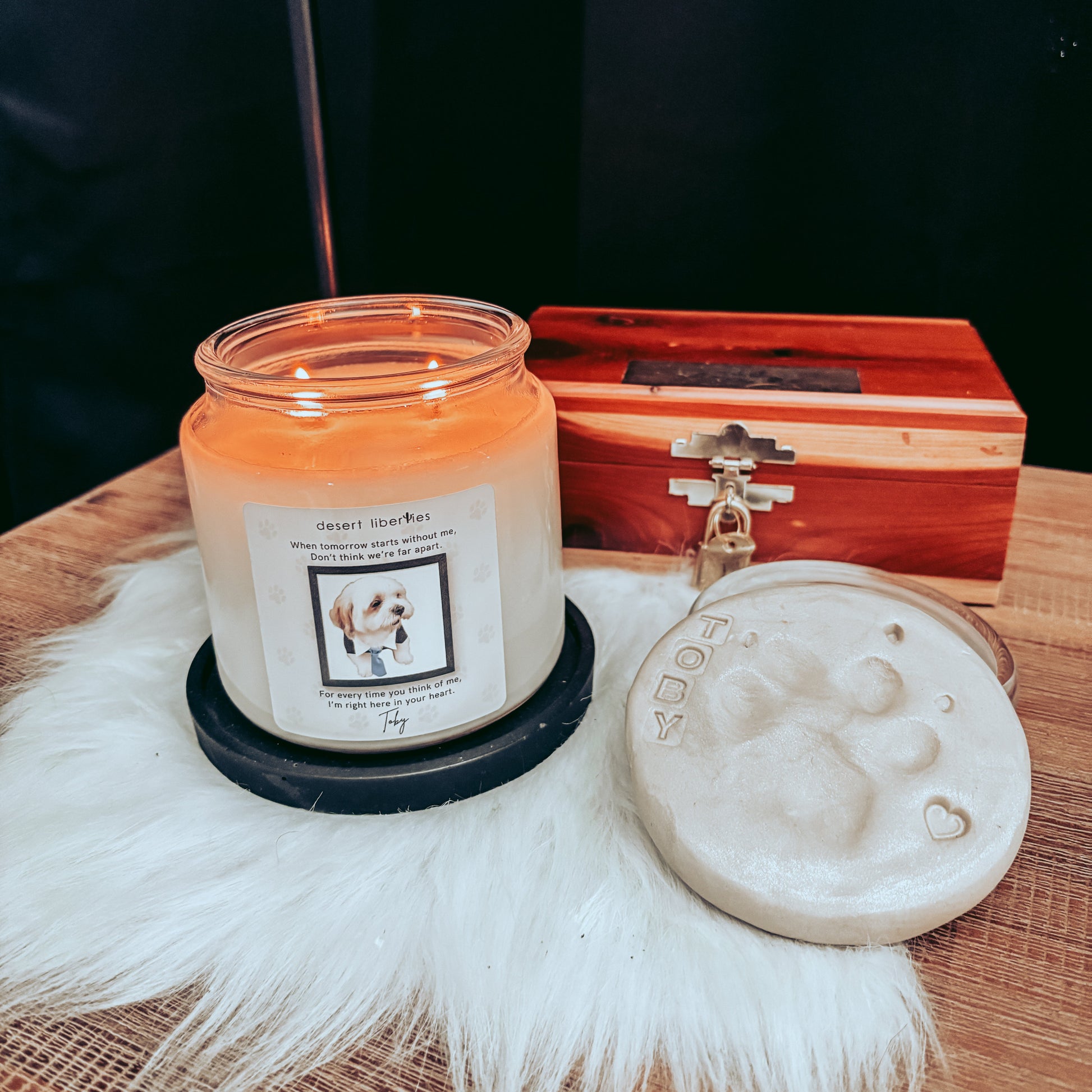 Candle with a wooden box and decorative item on a textured surface