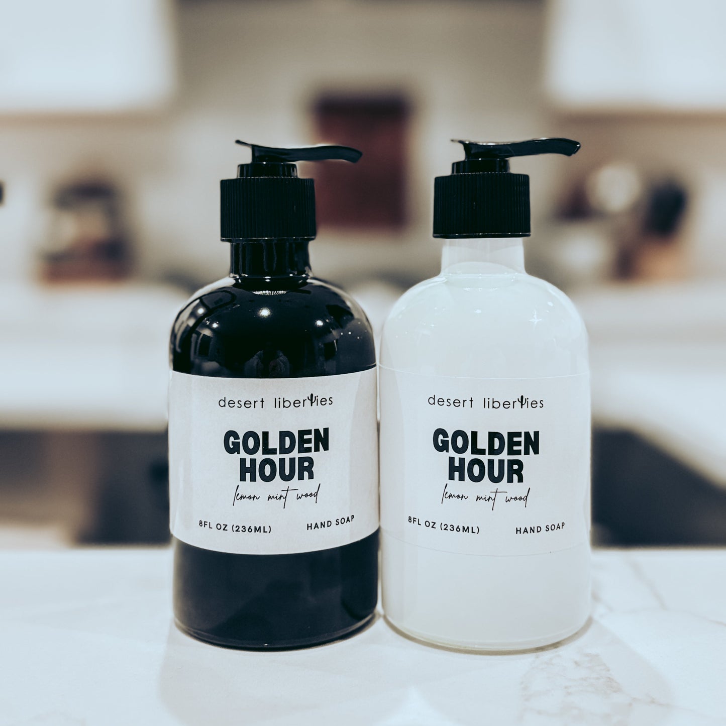 Two bottles of 'Golden Hour' hand soap on a surface with a blurred background
