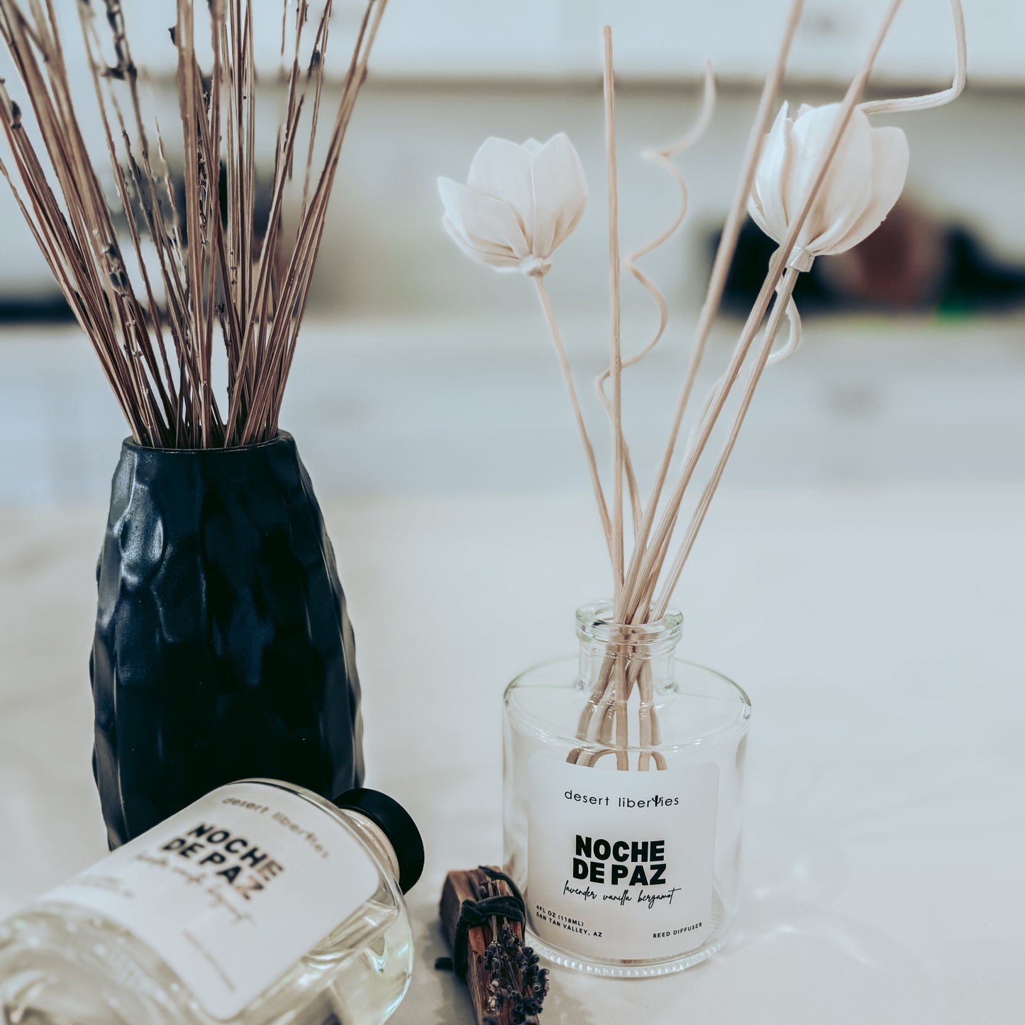 Decorative diffusers with 'Noche de Paz' labels on a marble surface