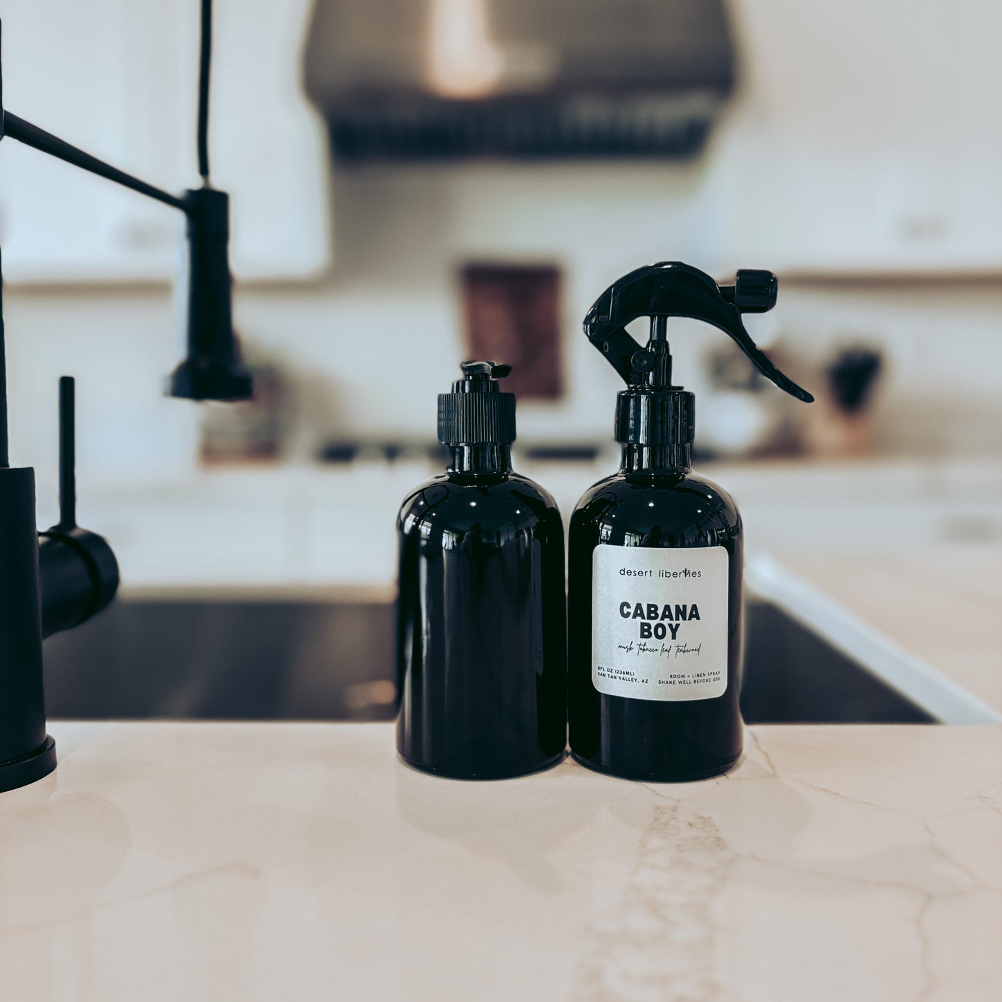 Two black bottles with labels on a kitchen counter
