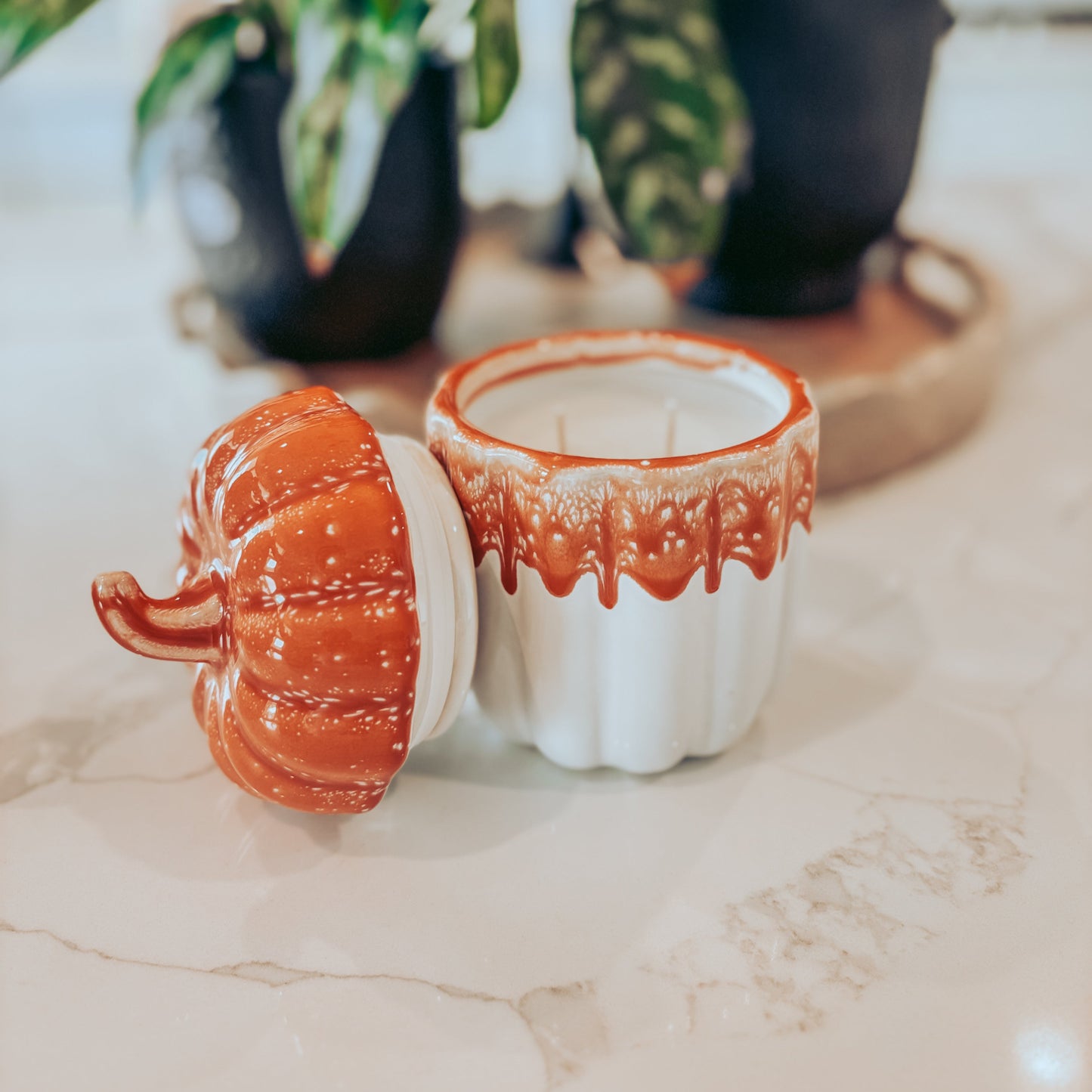 Ceramic container with orange and white design on a marble surface
