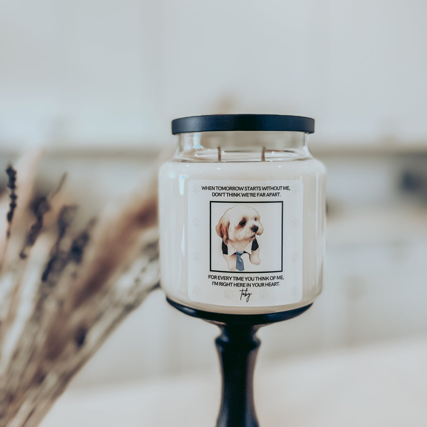 Candle with a label featuring a dog and text on a blurred background