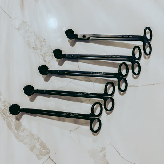 Set of black wick trimmers on a marble surface