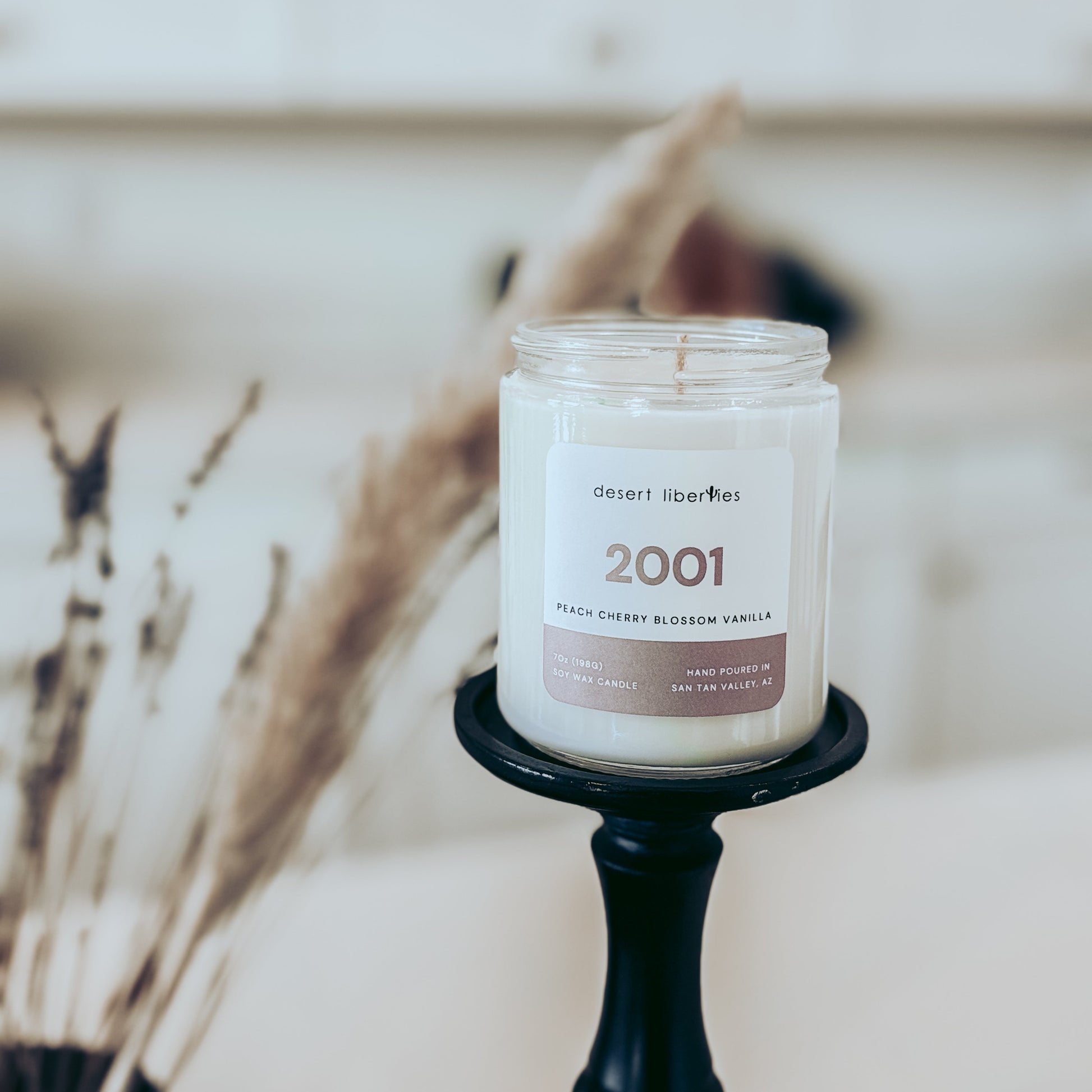 Candle labeled '2001' on a black holder with a blurred background