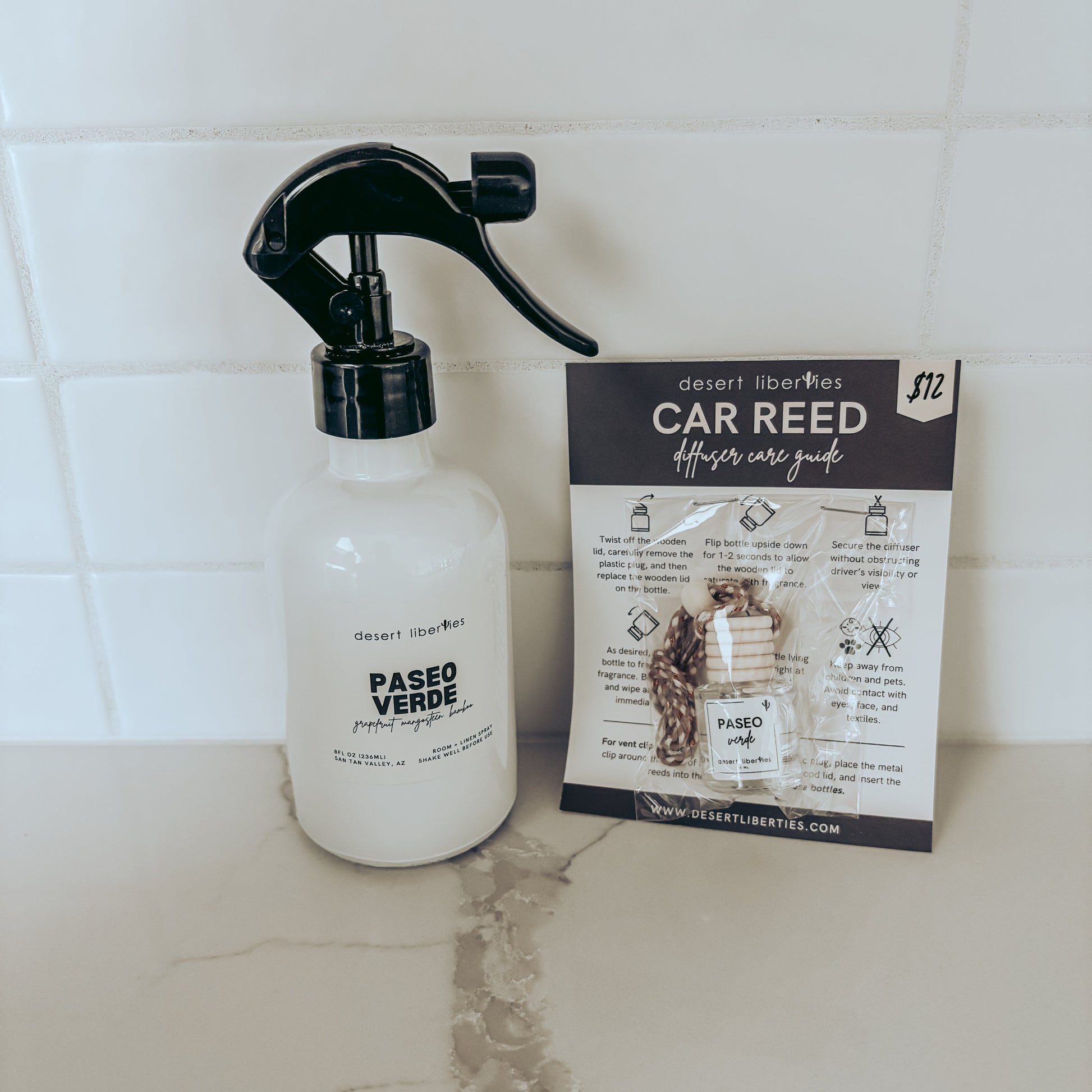 Spray bottle labeled 'Paseo Verde' next to a car care guide on a tiled surface.